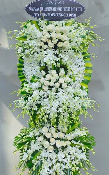 Lẵng hoa tang lễ với sự kết hợp của hoa lan và hoa hồng trắng.