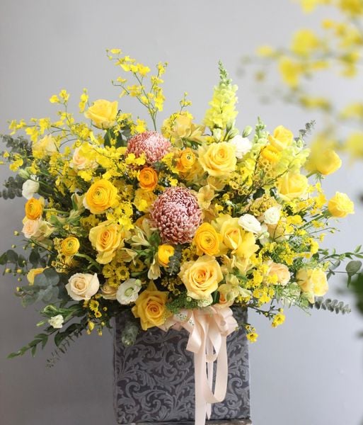 Giỏ hoa màu vàng với sự kết hợp của hoa phăng vàng, hoa lan vũ nữ, hoa hồng vàng và hoa cúc mẫu đơn trông cực kỳ bắt mắt.