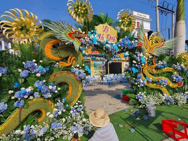 Một trong những cổng cưới với các nguyên liệu thuần miền Tây (lá dừa, tre,...) kết hợp cùng hoa tươi mang đến sự sặc sỡ và vẻ đẹp tuyệt vời cho ngày trọng đại.