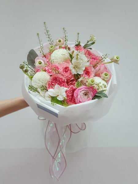 Bó hoa hồng dáng tròn xinh xắn được trang trí cẩn thận và khéo léo.