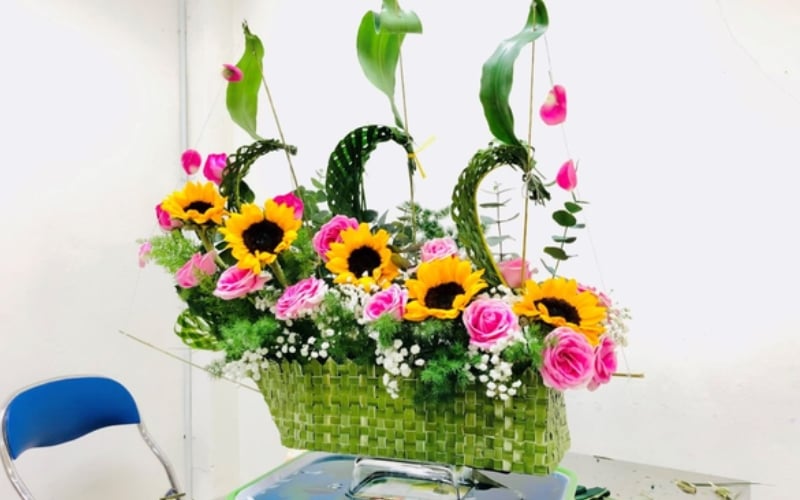 Bình hoa hồng nhiều màu được cắm theo hình con thuyền buồm