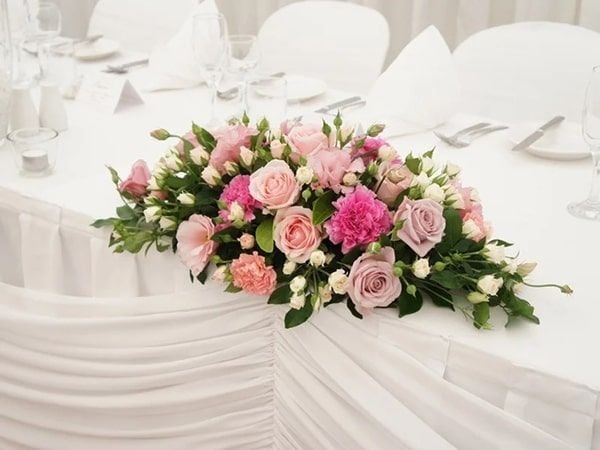 Những đóa hồng nở rộ nổi bật trên nền dải bàn tiệc hội nghị.