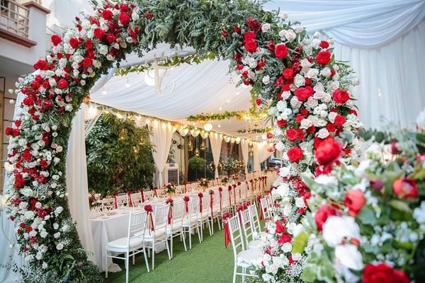 Cổng hoa lụa sặc sỡ sắc đỏ tươi thắm giúp buổi lễ thêm phần long trọng và quyến rũ hơn.