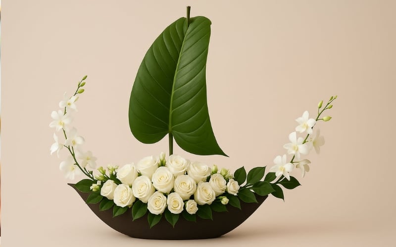 Bình hoa hồng và lan trắng được cắm trên đế hình thuyền với cánh buồm bằng lá