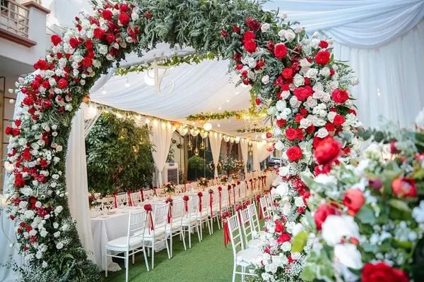 Cổng hoa lụa sặc sỡ sắc đỏ tươi thắm giúp buổi lễ thêm phần long trọng và quyến rũ hơn.